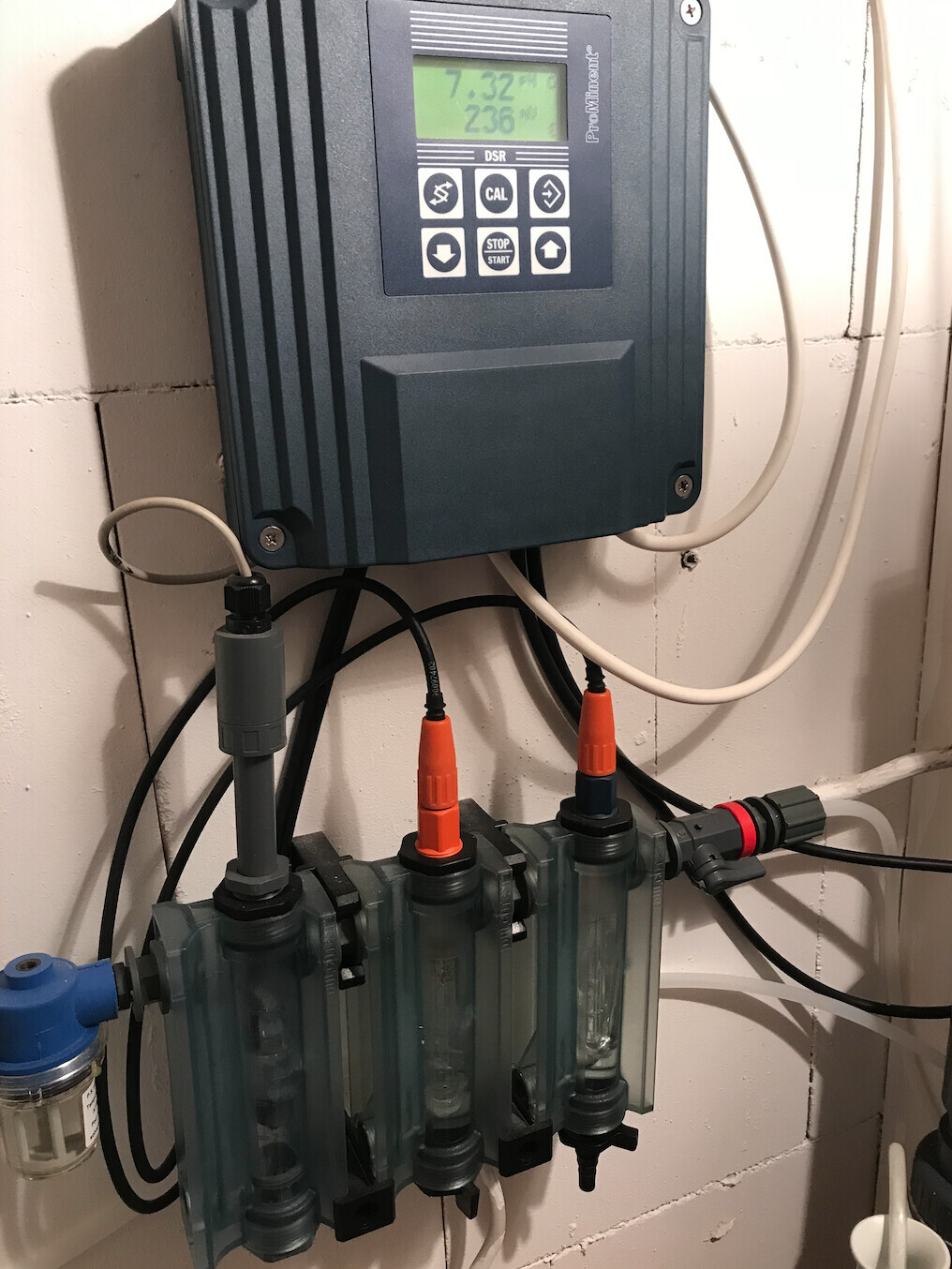 Dosierpumpe mit Display, Tastenfeld und Schlauchanschlüssen an der Wand.