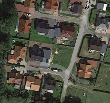 Aerial view of a residential area with houses, streets, and gardens