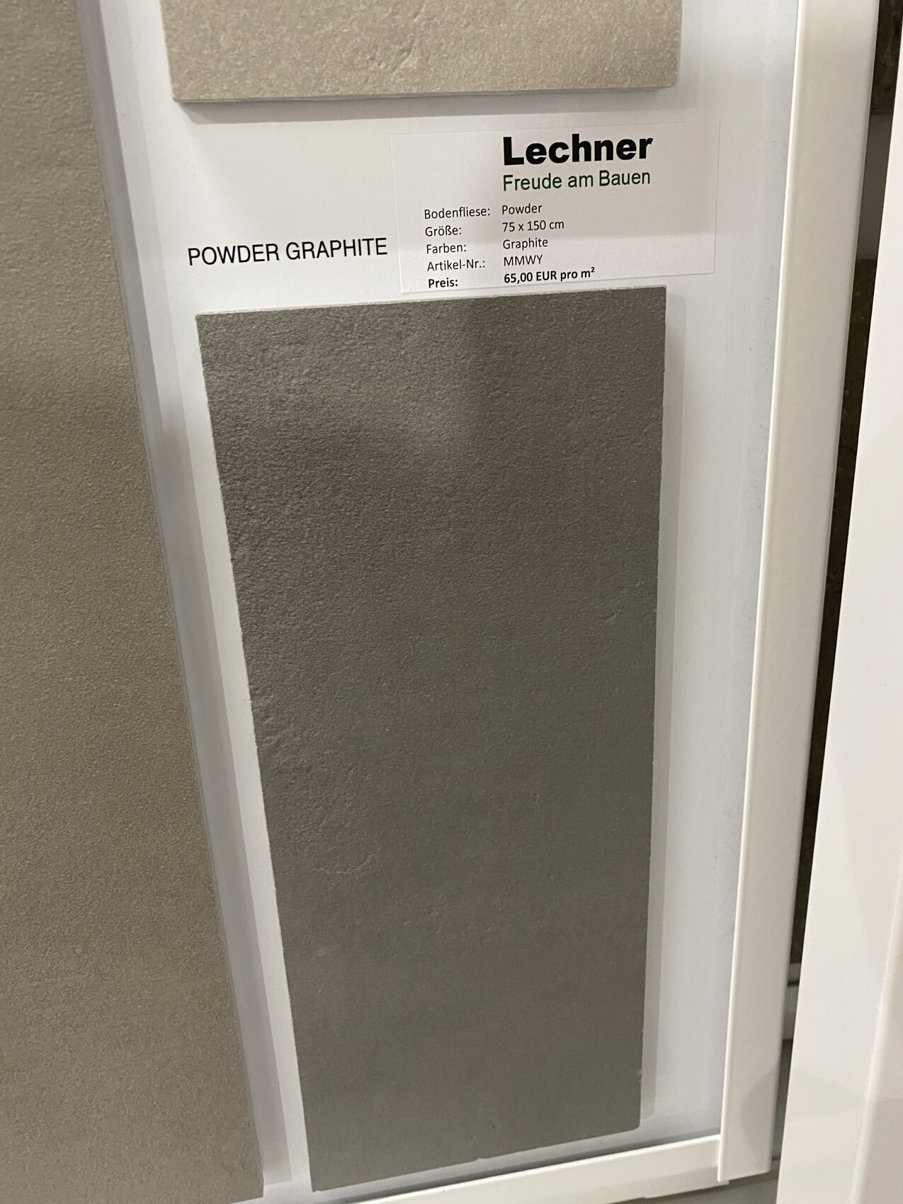 Display with gray graphite tile (Powder Graphite) and Lechner info card.