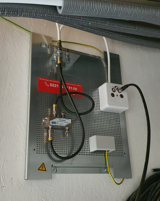 Electrical distribution panel with cables, coaxial connections, grounding, and surge protection.