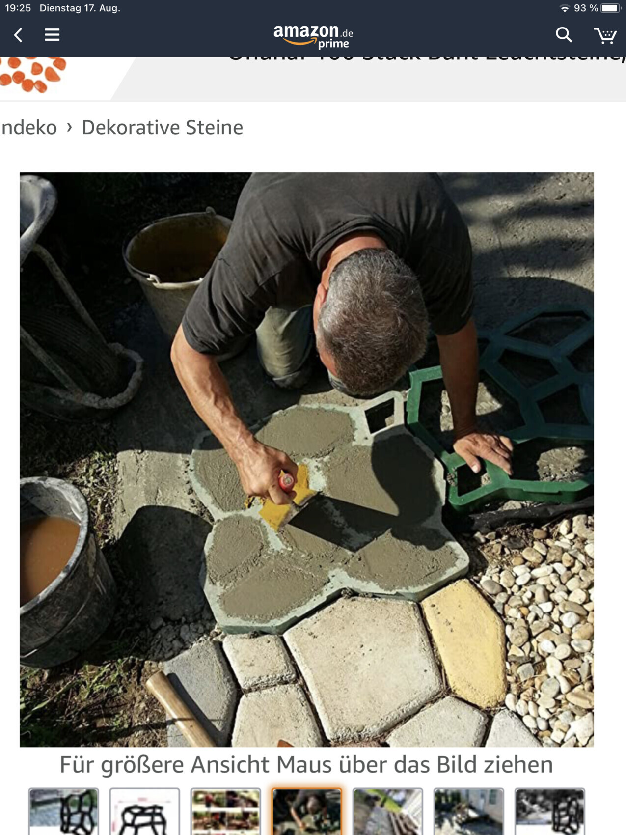 Craftsman laying gray decorative paving stones in a patterned pathway with cement.