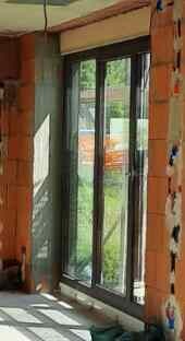 Unfinished interior with glass door and window under construction