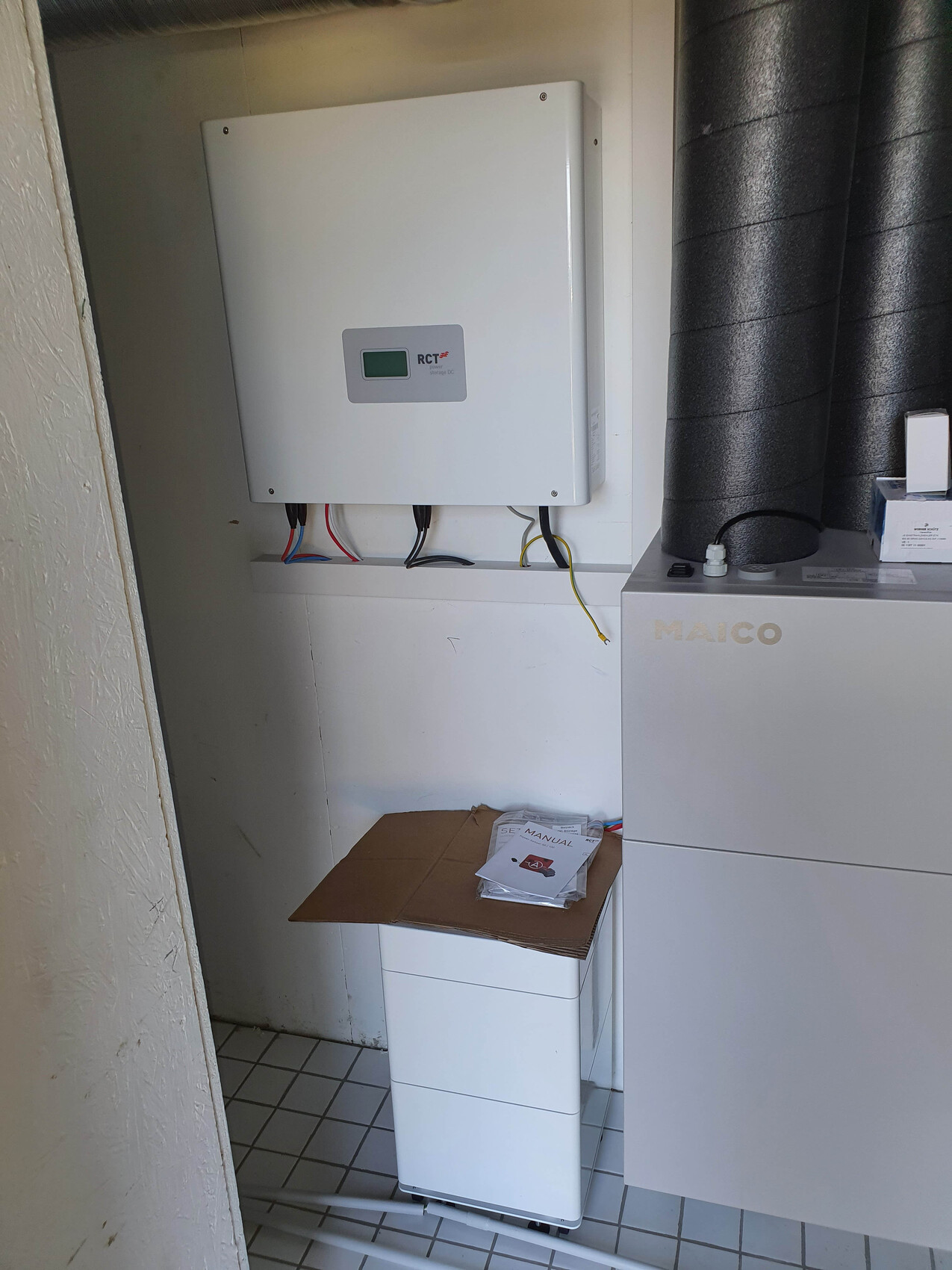 MAICO ventilation unit on the right, wall unit with cables on the left, box with manual on the cabinet.