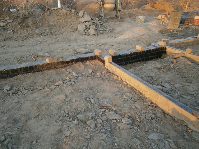 Baustelle mit Fundamenten aus Betonstein, Baugrube und losem Gestein