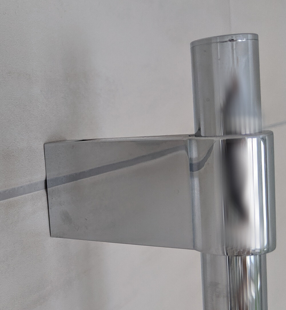 Chrome metal construction in a T-shape: vertical cylinder over a flat, horizontal bar.
