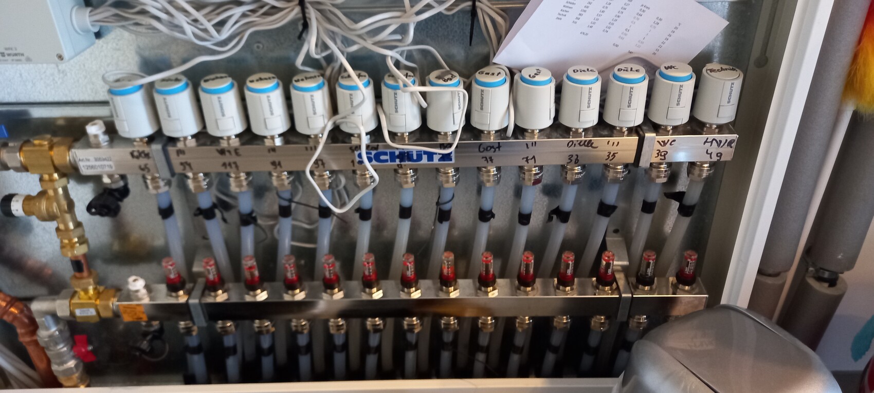Heating/hydraulic manifold with valve heads, hoses, and numbered labels.