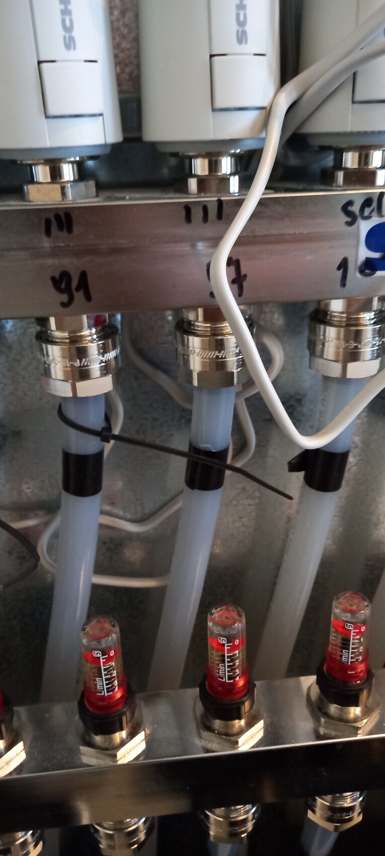 Pneumatic valve block with blue hoses, white control units, and red indicators.