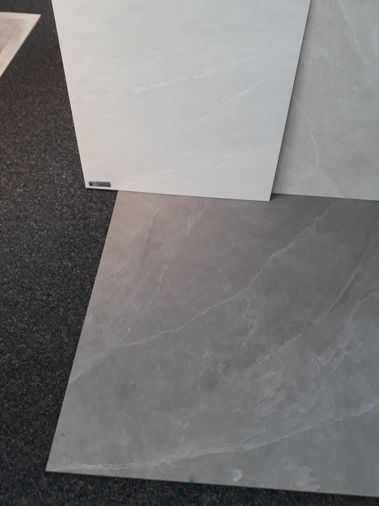 Grey tiles with marble pattern, several slabs overlapping at an angle.