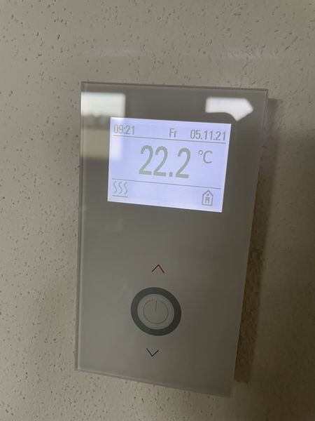 Wall thermostat with display showing 22.2 °C (72.0 °F), date and time; round knob below.