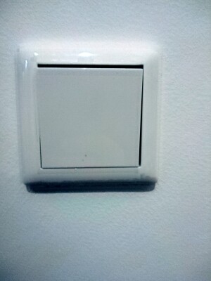 Close-up of a white light switch on a wall