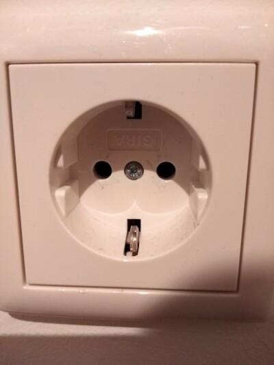 White Schuko wall socket with two round holes.