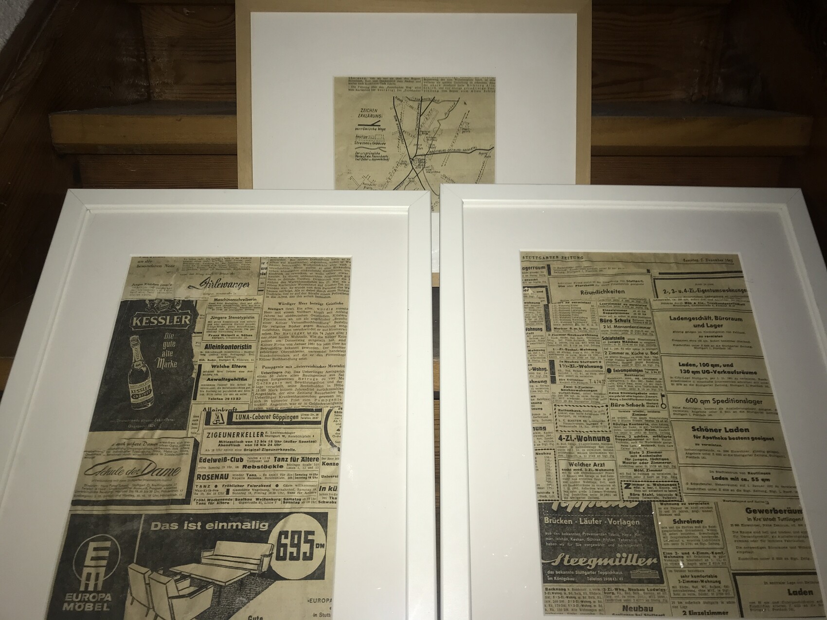 Three framed prints: two large newspaper clippings at the bottom, a map at the top.