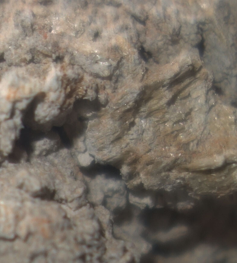 Close-up of a rough rock surface with fracture lines.