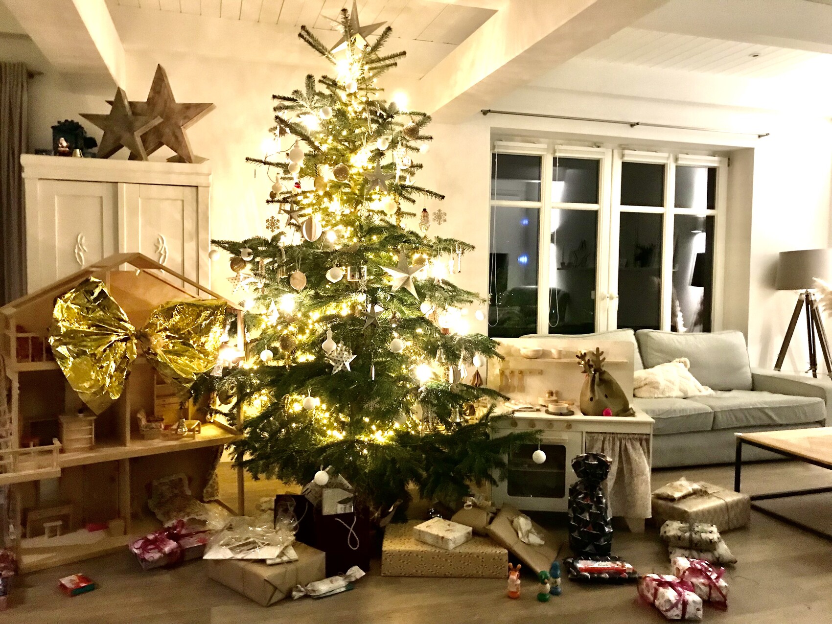 Christmas tree in the living room with lights, baubles, and presents underneath.