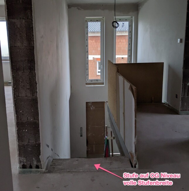 Shell construction: open staircase with railing, temporary installations, and windows.