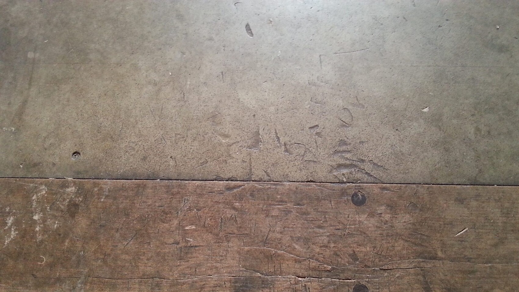 Weathered wooden floorboards with visible nails and scratches