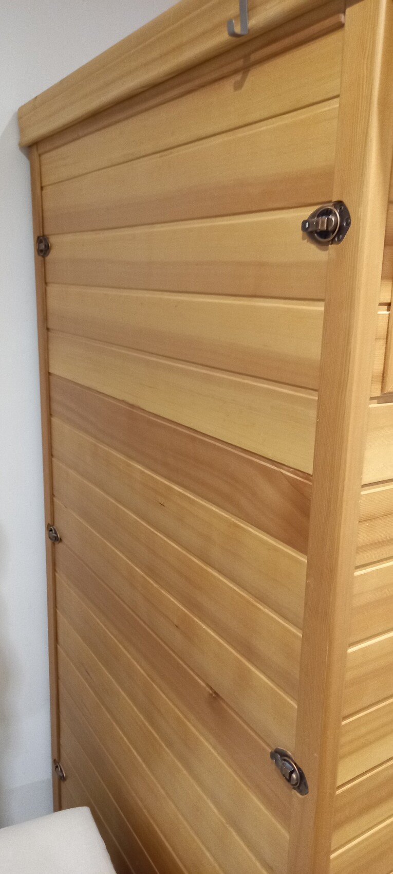 Wooden door with horizontal wood slats, metal fasteners, and wood frame.