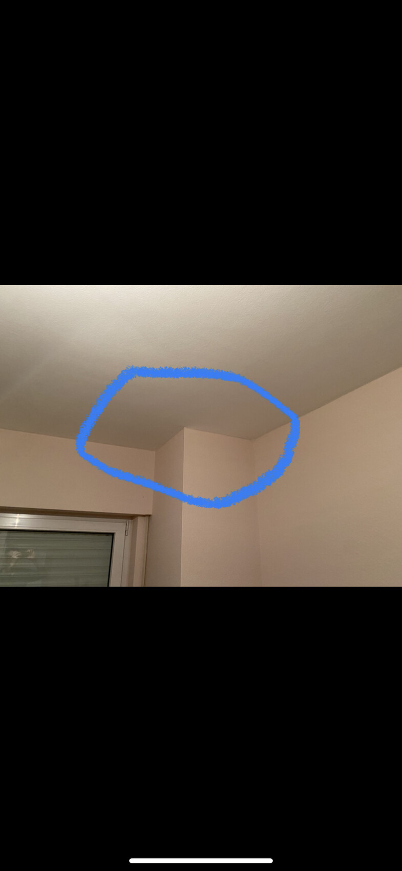 Interior corner with wall projection near the ceiling; blue highlighted area marks the transition.