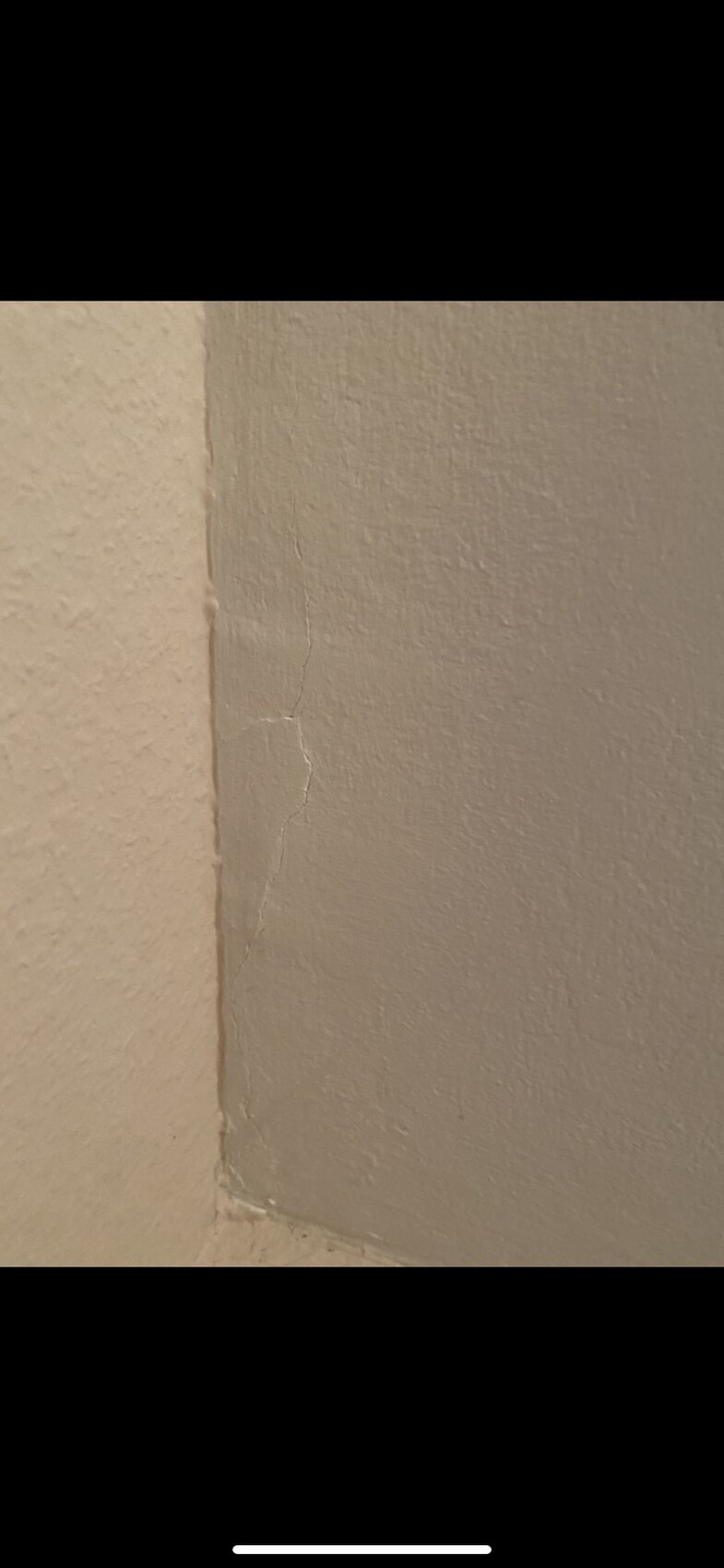 Corner area of two walls with a fine crack in the plaster