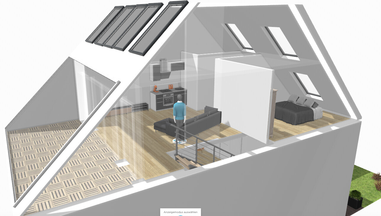 A person stands in the open attic with kitchen, living room, bedroom, and stairs.