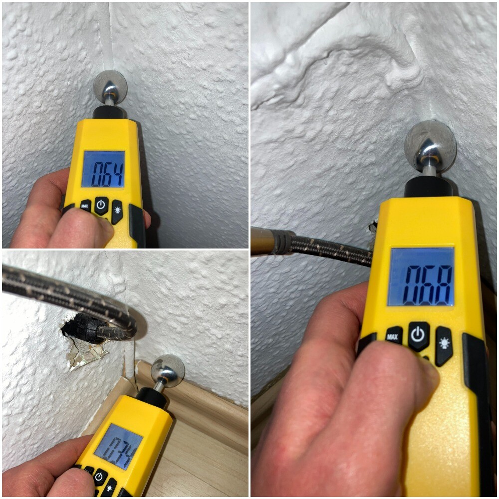 Digital moisture meter measuring dampness on rough interior wall; readings around 0.6.