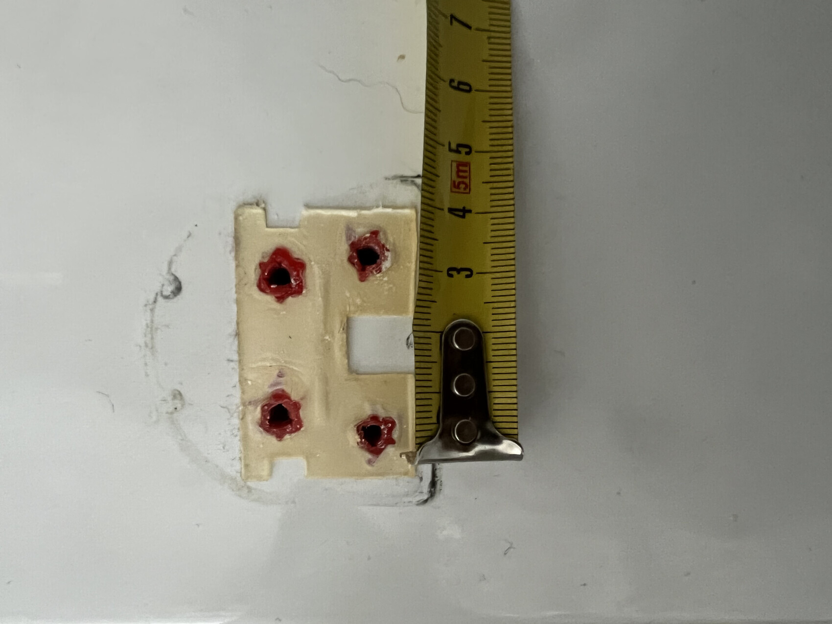 Wall mounting: electrical box with screws, measuring tape next to it for measurement