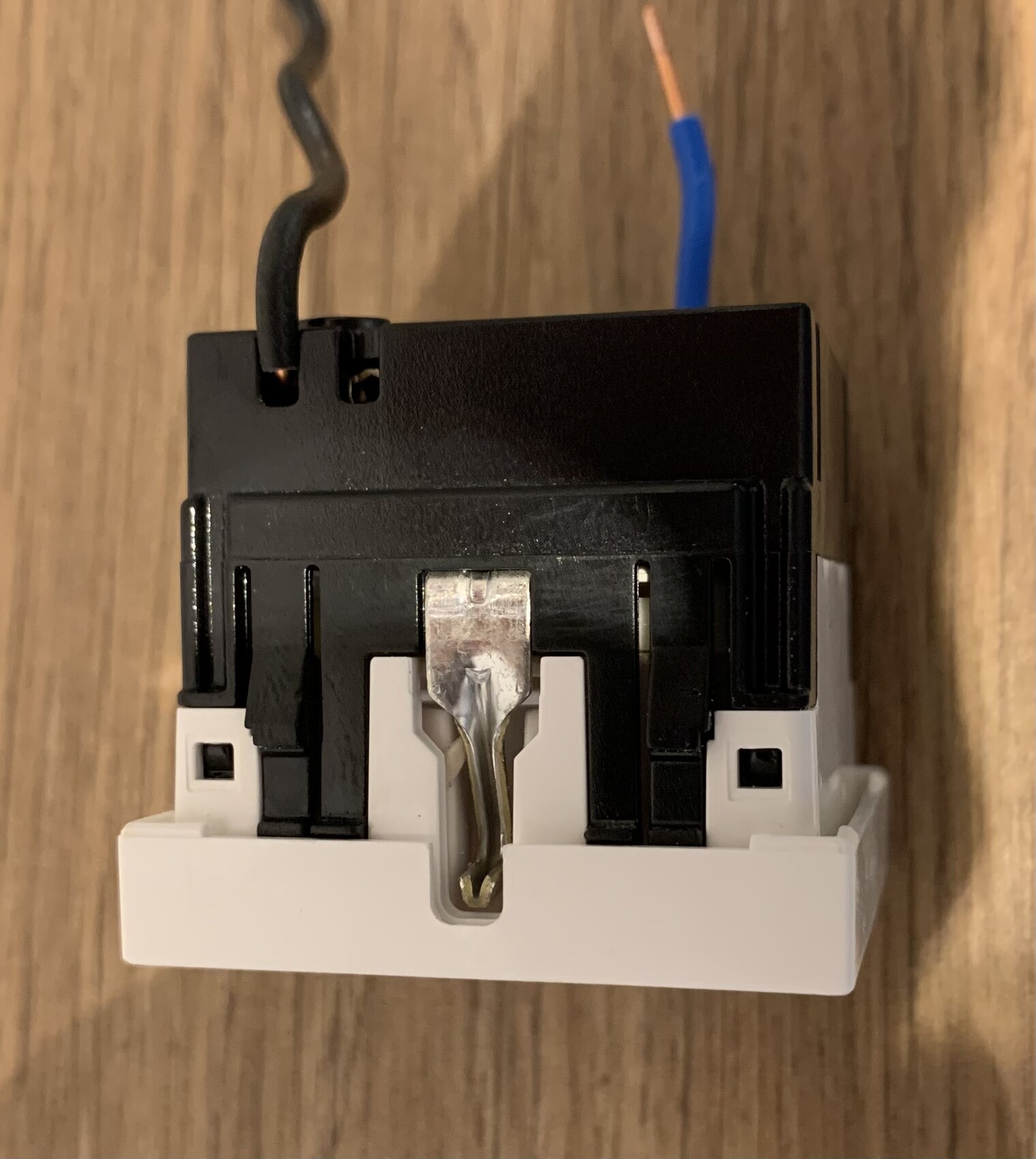 Electrical component/relay with black top, white base; blue and black cables.