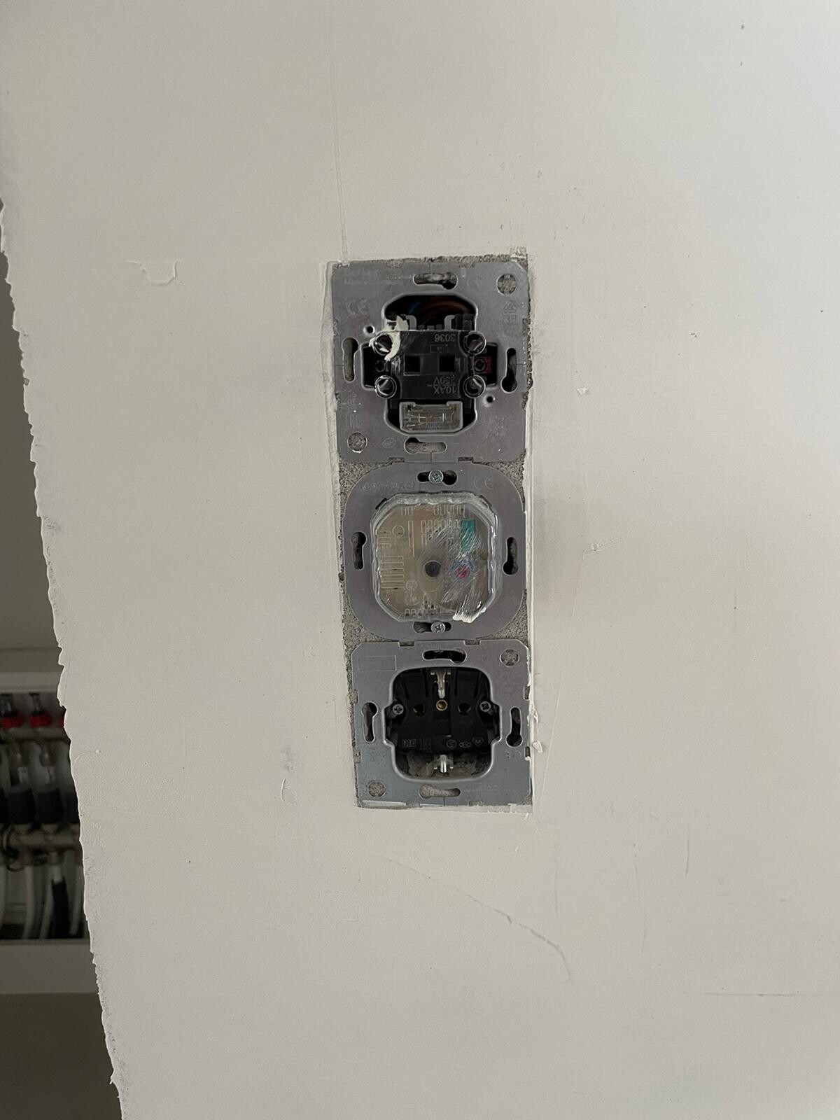 Vertical wall electrical panel with three open modules (switches/sockets).