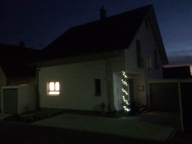 Night photo of a house with illuminated entrance and window