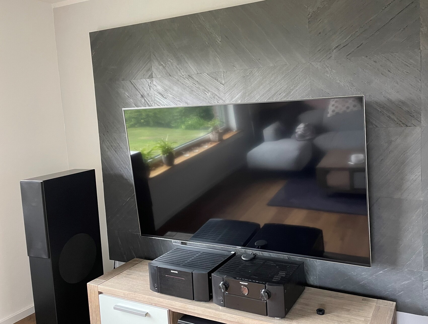 Modern living room: large flat-screen TV, floor-standing speakers, and hi-fi system.