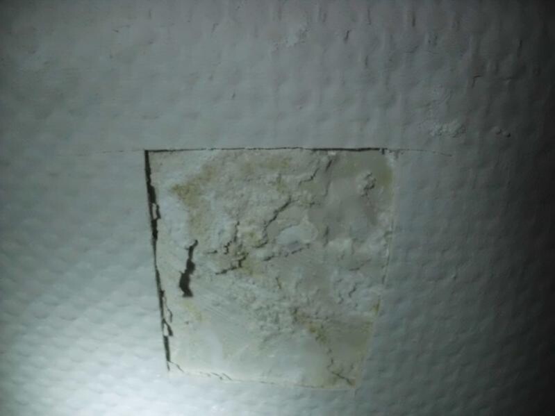 Worn wall with plaster cracks and damaged plaster layer.