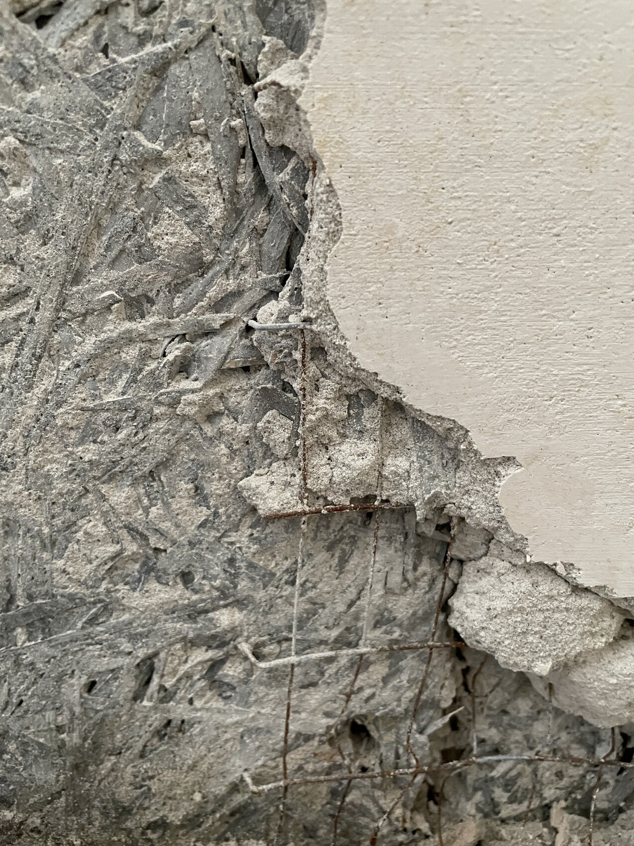 Cracked wall with exposed reinforcement and broken concrete