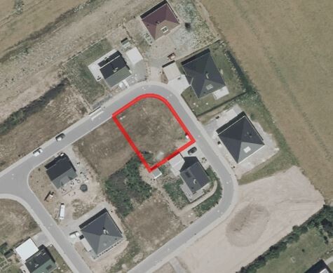 Aerial view of a residential area with red plot highlight and surrounding houses