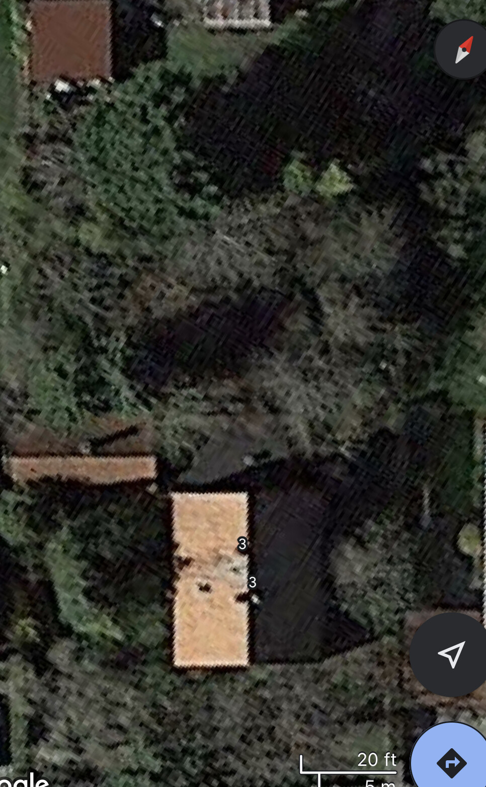 Aerial view of an orange tiled roof, surrounded by trees and green area