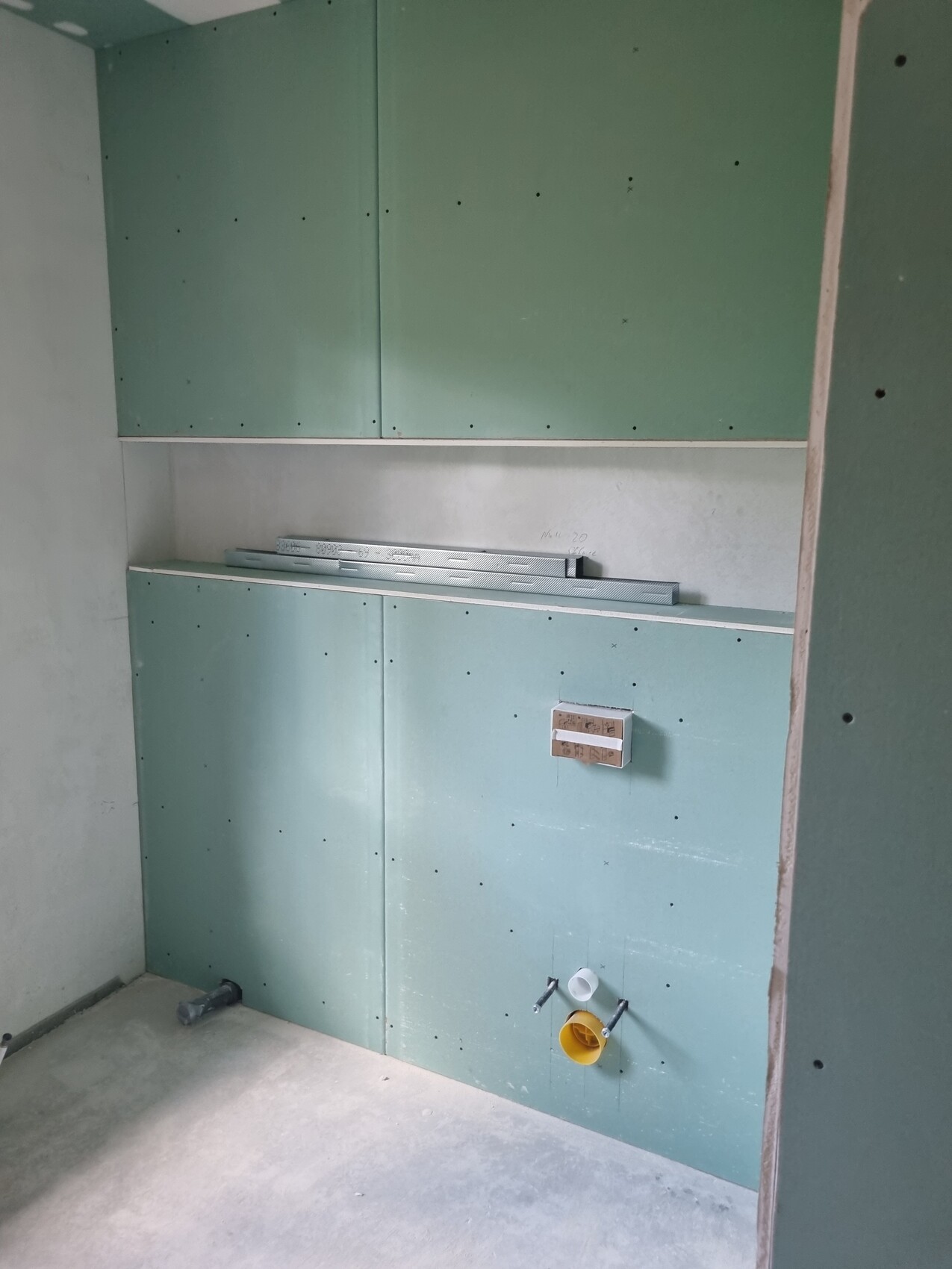 Construction status: green drywall panels, installations for sink at bottom right.