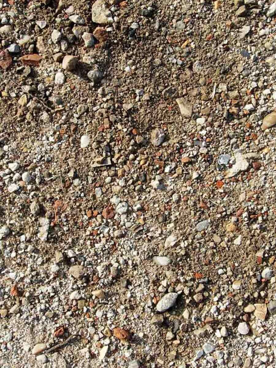 Close-up of coarse gravel, soil, and crushed stone as subsoil