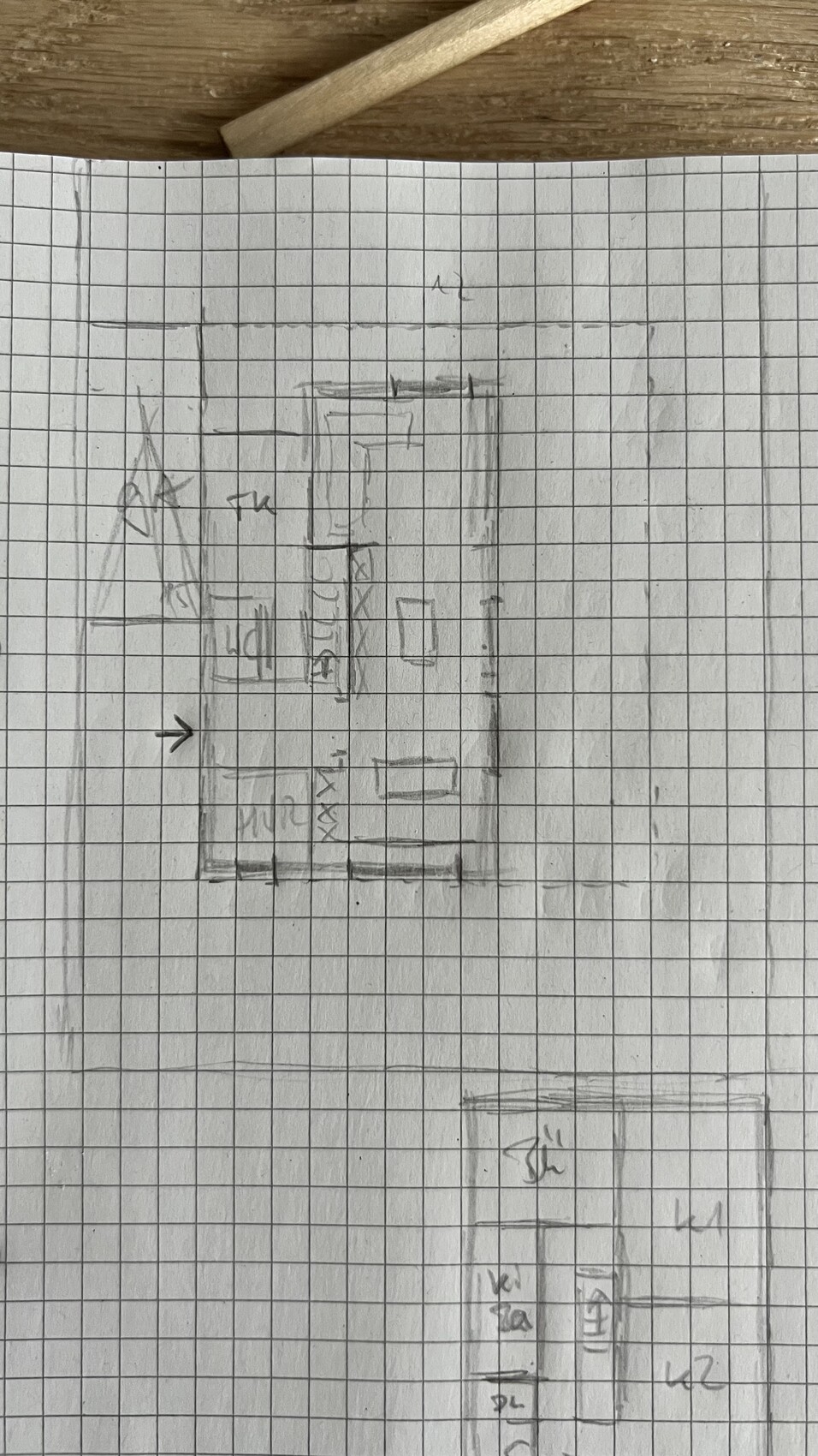 Handgezeichnete Skizze eines Grundrisses mit Zimmern auf kariertem Papier.