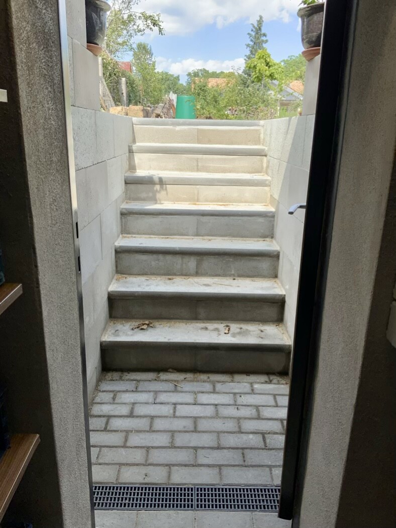 Concrete steps in the entrance area, side walls, view outside to the garden