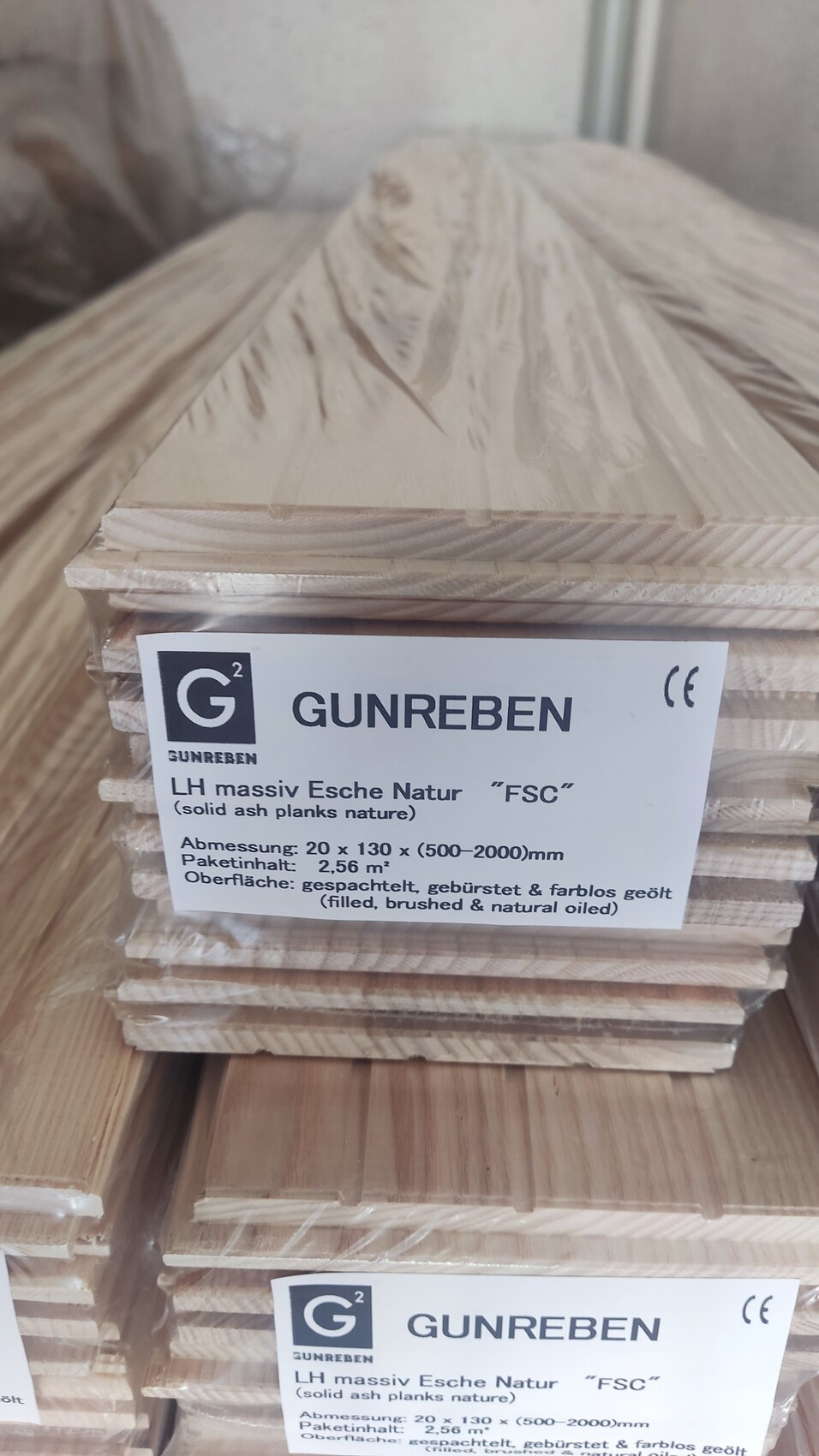 Stack of light ash wood planks, FSC-certified, label with GUNREBEN on top