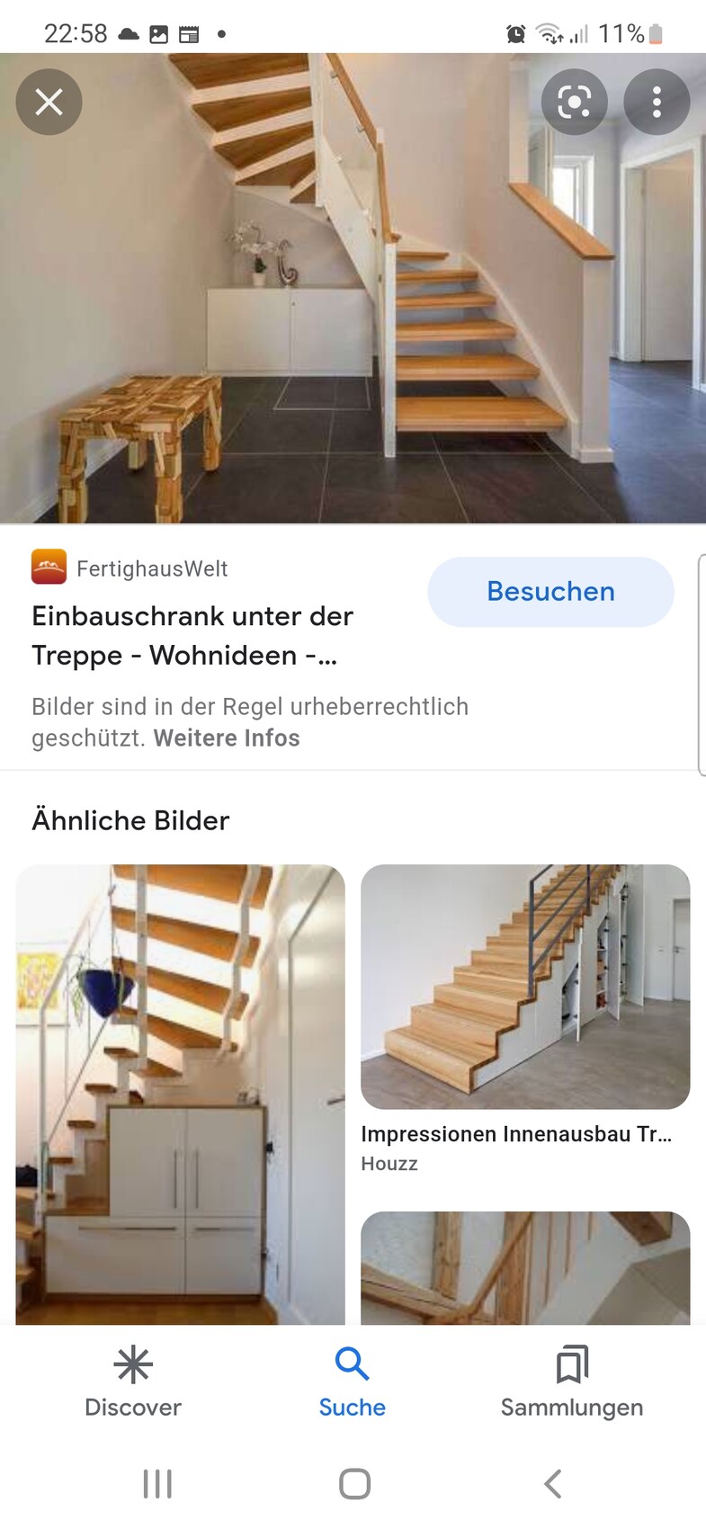 Modern wooden staircase with open steps; underneath a white cabinet and dark tiles in the entrance