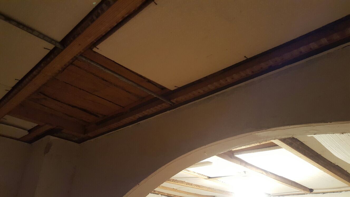 Interior view of a renovation room with exposed wooden beam ceilings and arch structures.