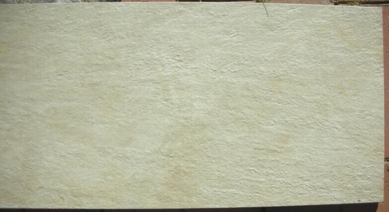 Cream-colored, roughly textured plaster surface/wall; right edge visible.