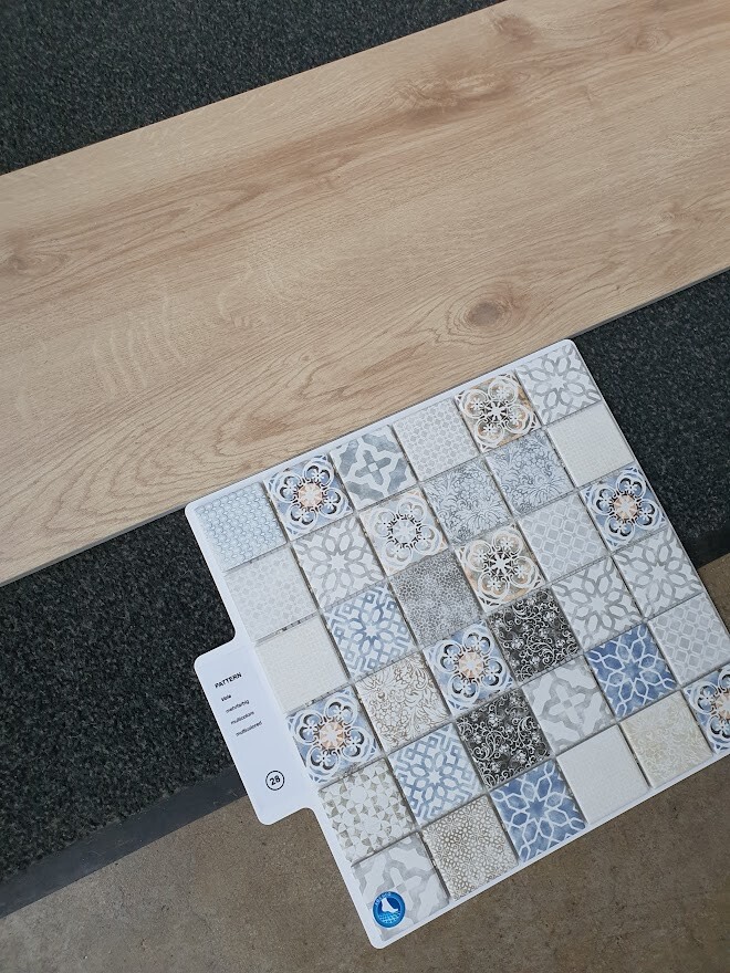 Various sample ceramic tiles as floor coverings next to a wood panel