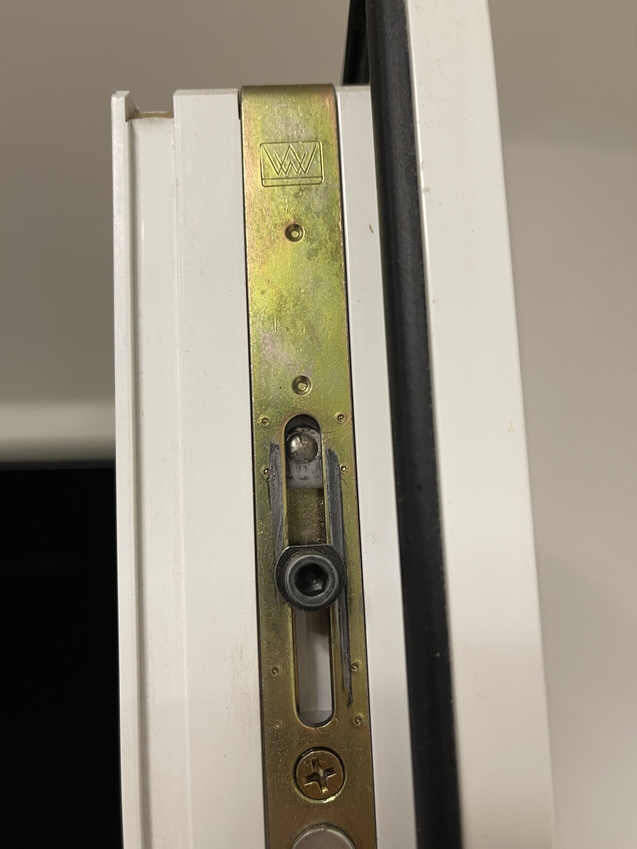 Close-up of a white door frame with brass strike plate and latch.