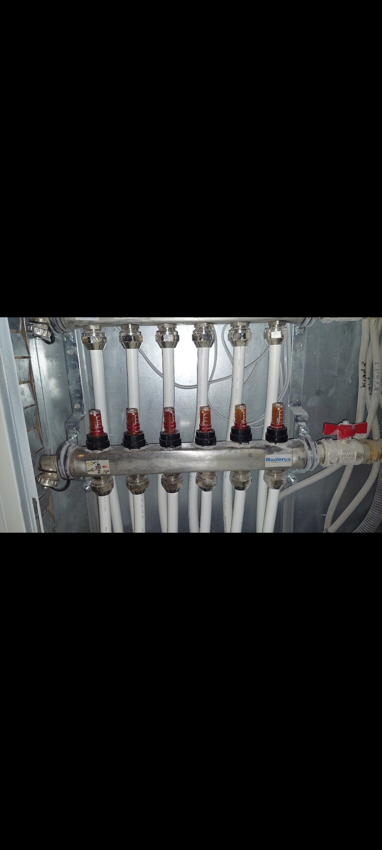 Distribution system with white heating pipes, red valves, and Buderus marking.