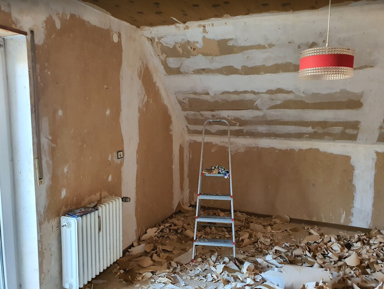 Renovation room: ladder in the middle, plaster debris on the floor, red lampshade.