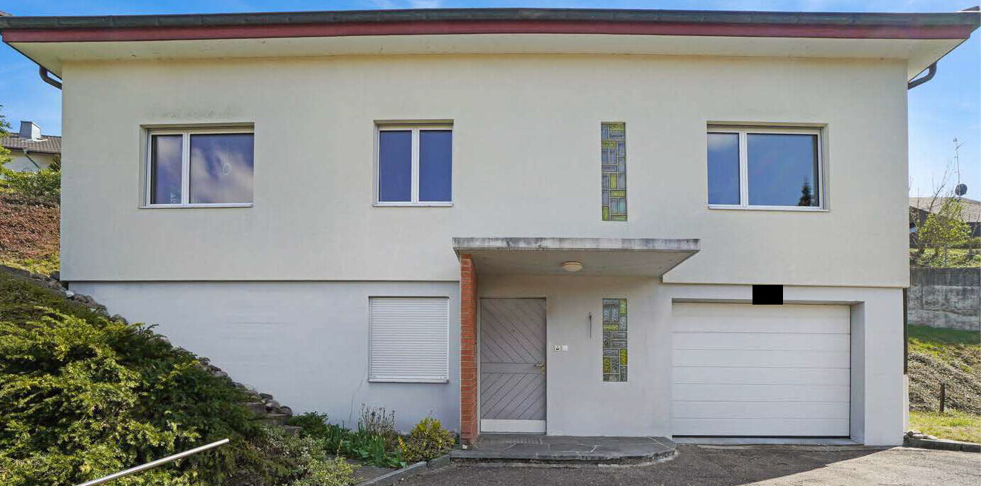 Two-story house with garage, white facade, entrance under porch roof.