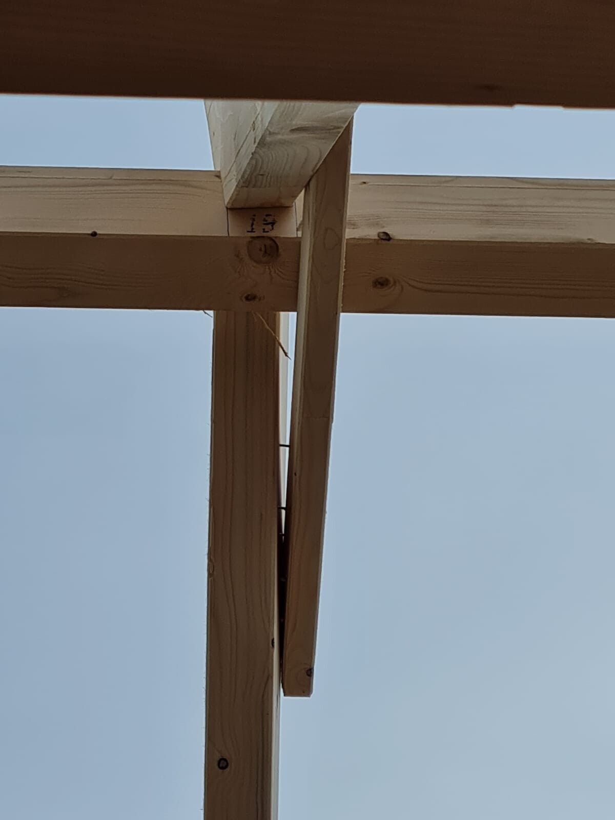 Holzrahmen-Konstruktion aus Balken und Stützen, Blick nach oben auf Bauwerk