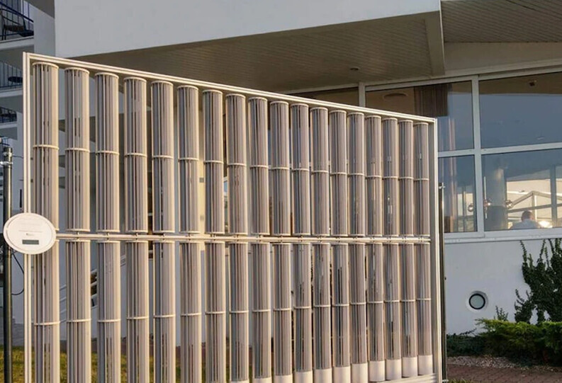 Modern office building behind vertical metal fence with glass windows; round sign on the fence