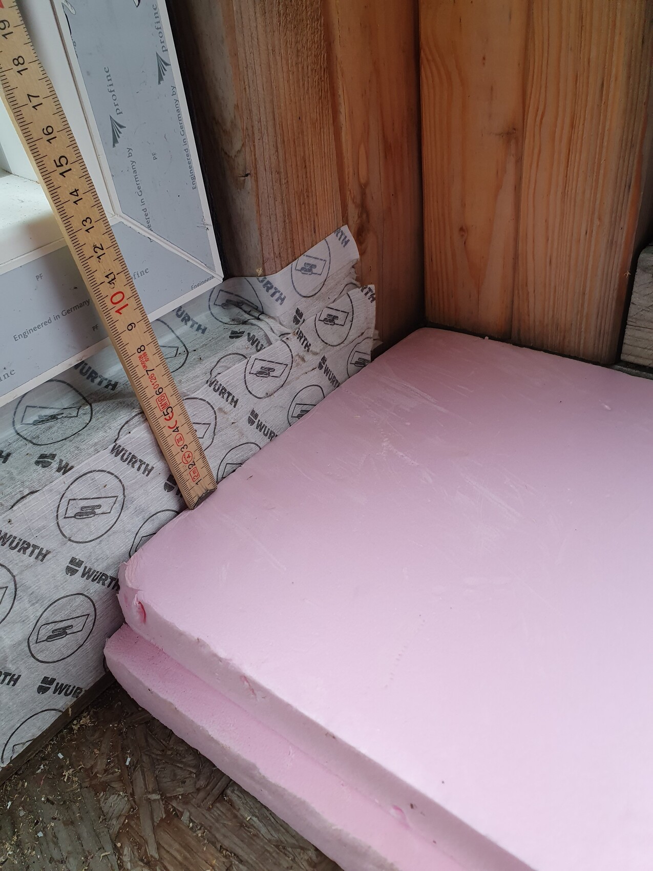 Pinkfarbene Dämmplatten neben Holzrahmen in einer Baukonstruktion
